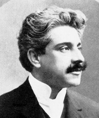 Retrato em preto e branco de Oswaldo Cruz, médico sanitarista brasileiro, com cabelo ondulado e bigode espesso, usando terno e camisa com colarinho alto.