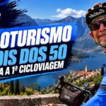 Casal de ciclistas maduros pedalando em estrada rural com alforjes, durante uma cicloviagem